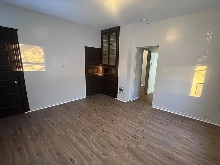 Primary bedroom with natural light and updated flooring