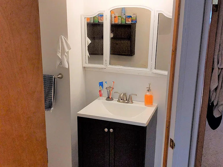 Charming antique 3-pane mirror accents the vanity/sink.