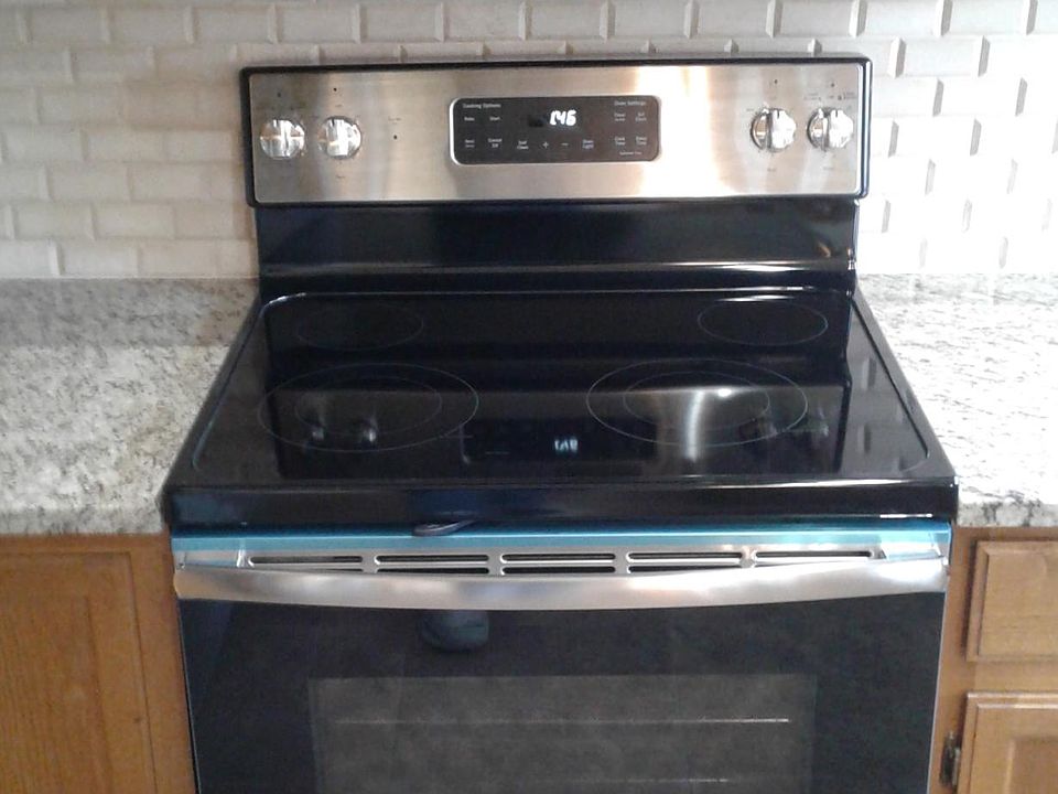 Stainless steel appliances with marble stone backsplash and granite countertops.