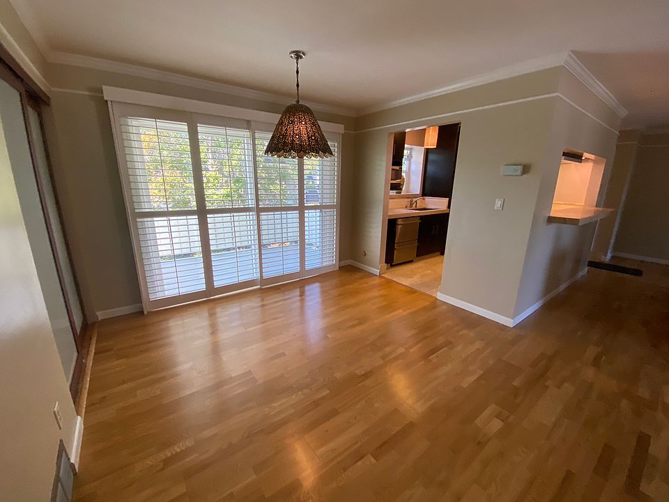 Dining room, balcony through windows, kitchen through open door