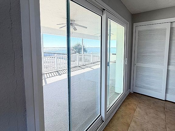 Bright interior featuring large sliding glass doors opening to a spacious balcony with stunning ocean views.