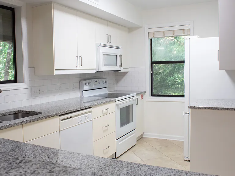 Back inside, the kitchen features a double-basin sink with an extendable faucet, a dishwasher, an electric range, a microwave and a refrigerator/freezer.