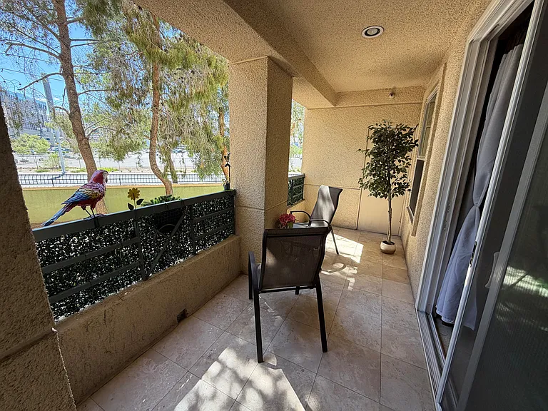 Big balcony with partial Las Vegas Strip views, including Bellagio, Flamingo, Monorail, and the LINQ High Roller, shaded by mature trees - it offers a relaxing outdoor retreat.