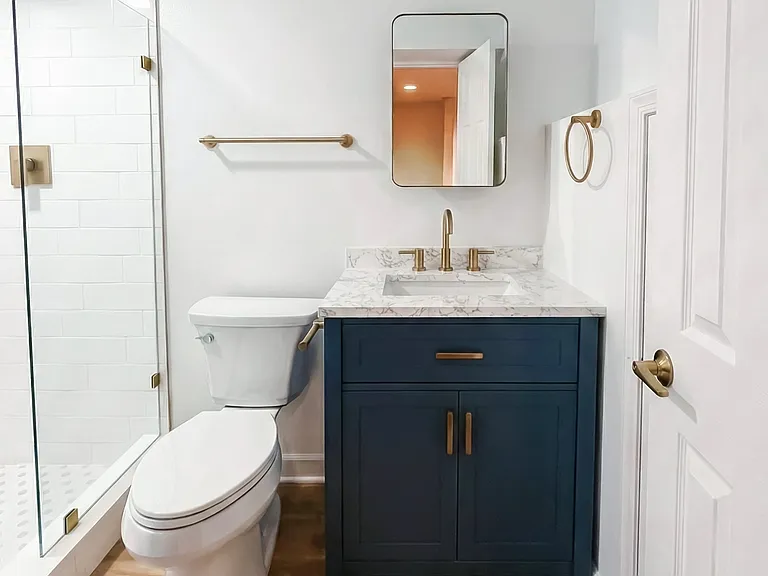 Bathroom view with updated vanity, toilet, towel storage, and modern finishes.
