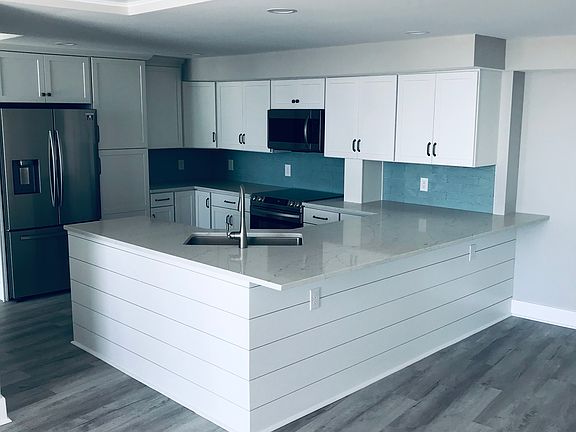Custom-made shiplap surrounds this massive peninsula. Custom shiplap ceiling shown.