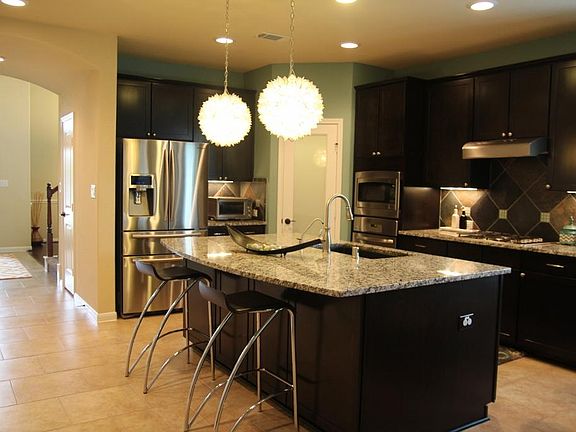 Island kitchen with ample seating and custom light fixtures!