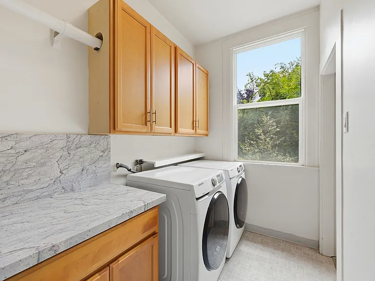 Laundry Room with full sized washer and dryer and storage