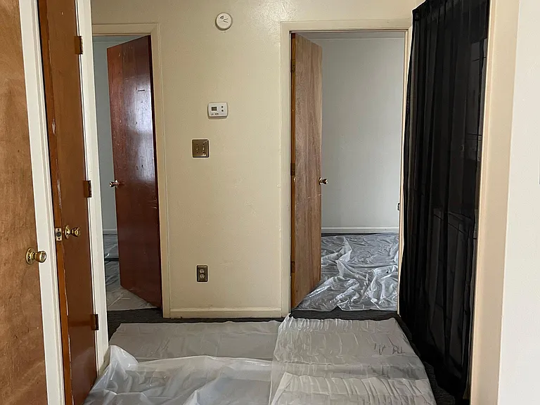 Hallway, with utility area behind the black curtain; with stackable washer and dryer