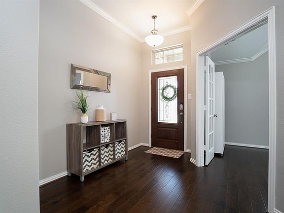 A pretty leaded glass front door with transom windows allows the natural light to flow into this open entry!