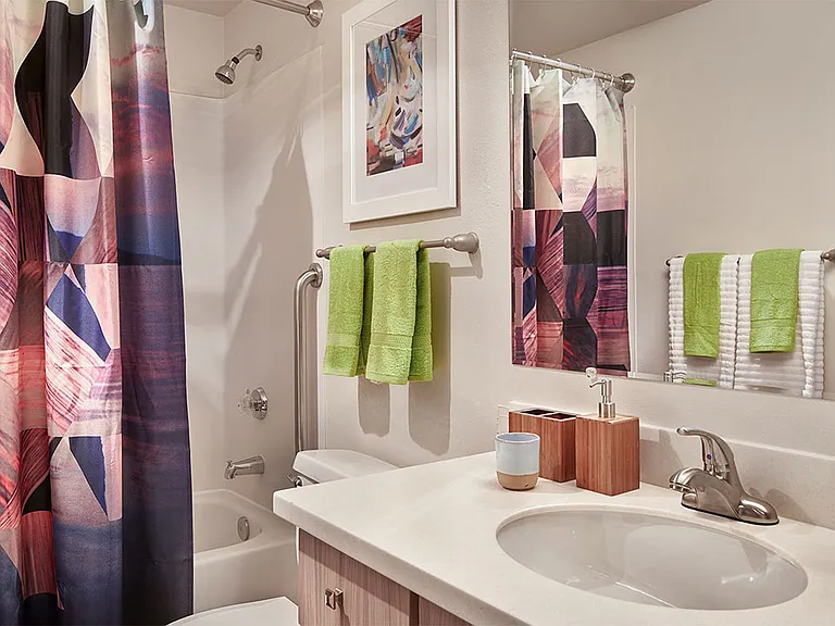 Apartment bathroom with wood-style flooring.