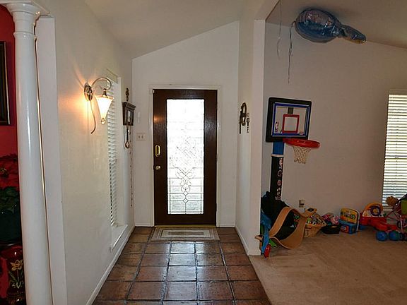 Entry with a beveled glass door, Saltillo tile flooring and raised ceilings.
