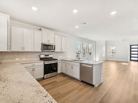 Kitchen and entry in the Medina floorplan at a Meritage Homes community.
