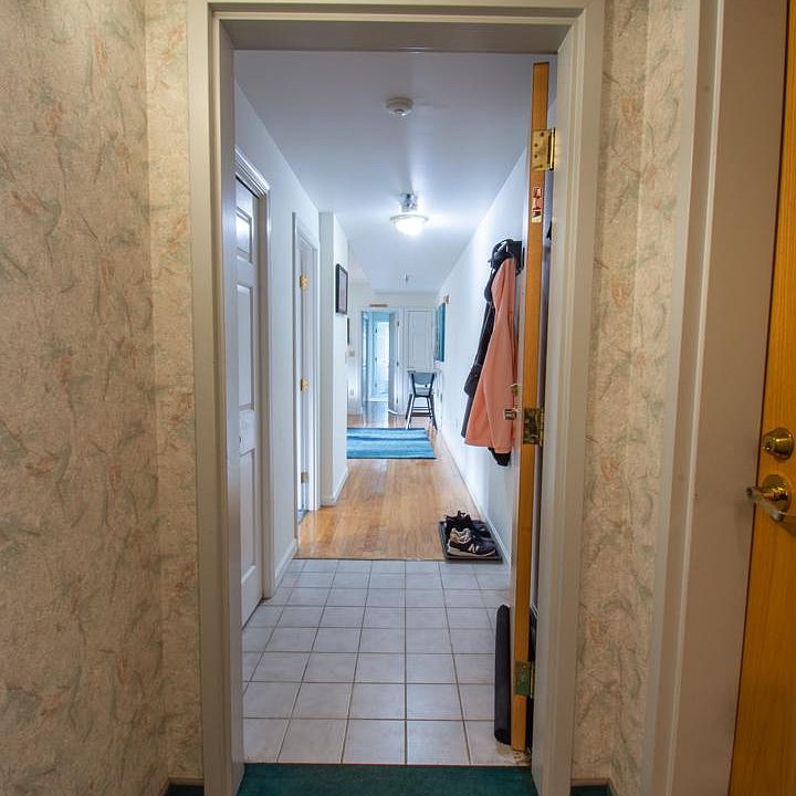 Entrance to apartment, coat closet on the left, followed by master bedroom