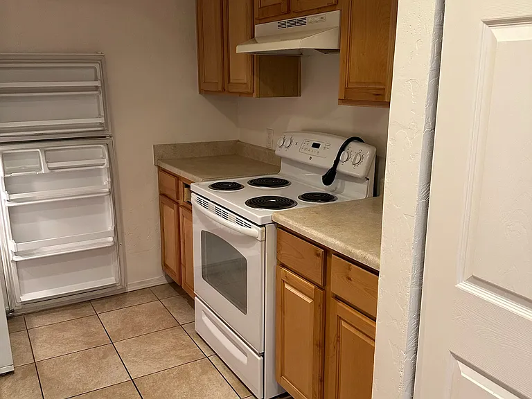 kitchen with electric stove and refrigerator