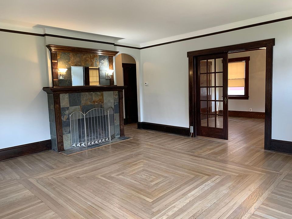 Living room with cozy wood burning fireplace open to dining room