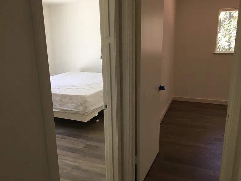 Looking to the bedrooms from the bathroom door.
That's a California King bed, pulled away from the wall about three or four feet (for painting).