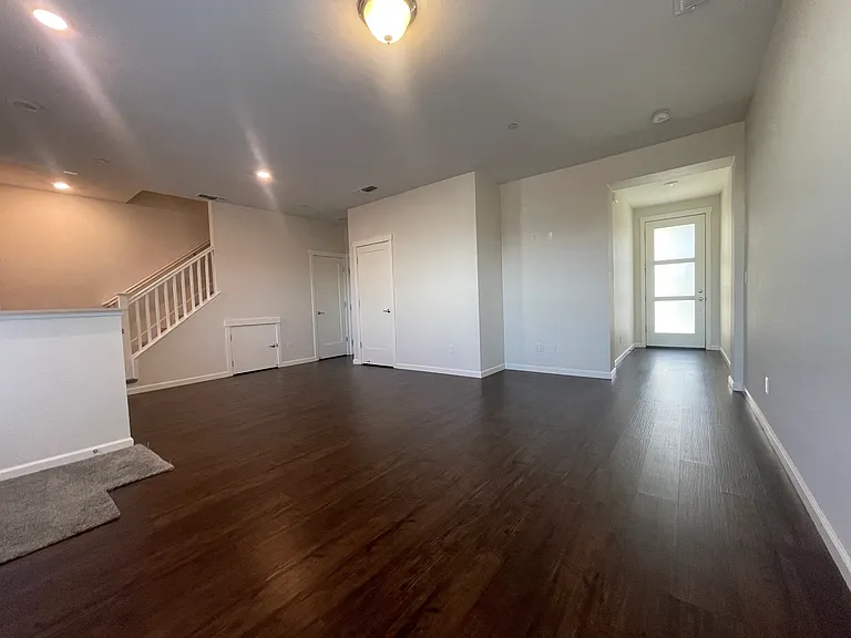 Living room with view of the front door and stairs to second story
