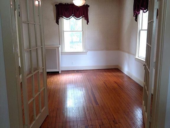 Sunny, full-sized Dining Room with original, refinished wood floors