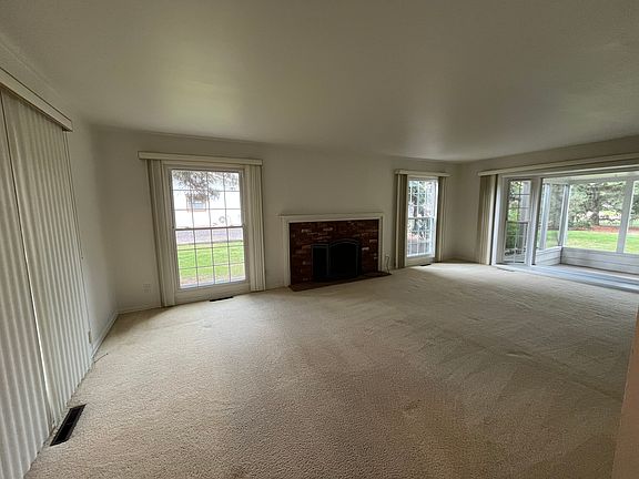 Formal Living Room with fireplace and beautiful bay window that looks out into the screened patio