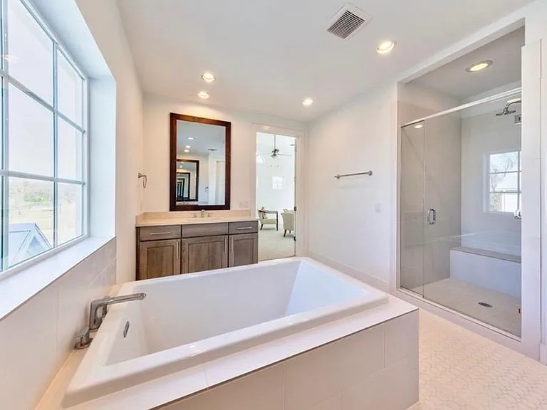 Primary bathroom has a soaking tub, a walk-in shower, and dual vanities.