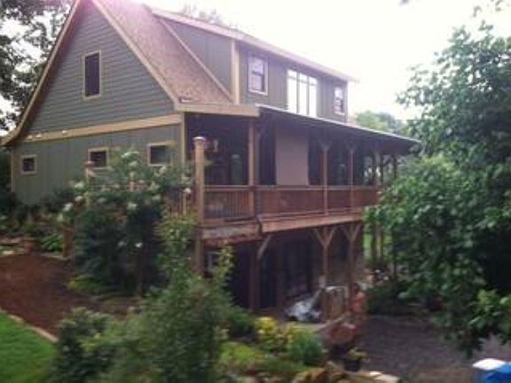 View from the nw side of the house. Shows walk out lower level, and garage. Porch with doors to master and dining.