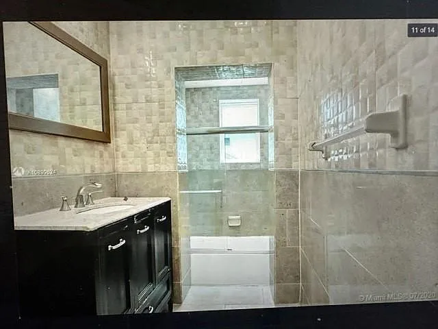 long view of this incredible bathroom with super nice shower and dual flush one piece toilet