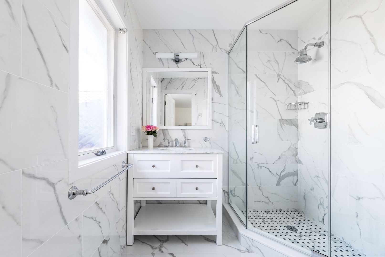  En-suite guest bathroom features marble interiors. Walk-in rain shower and vanity sink.
