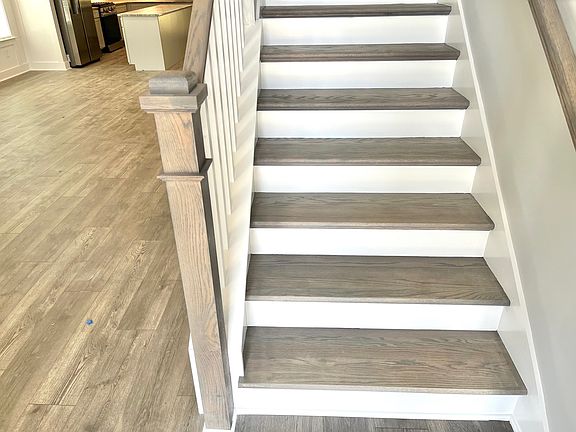 Custom stained oak stair treads with Craftsman style spindles great you at the entry.