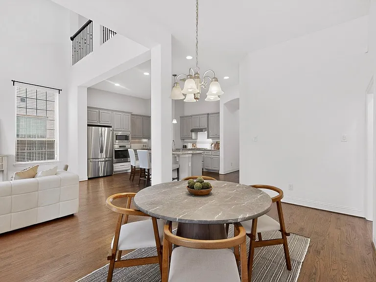 Spacious dining area showcasing elegant hardwood floors and a chandelier, blending style and comfort for everyday living.