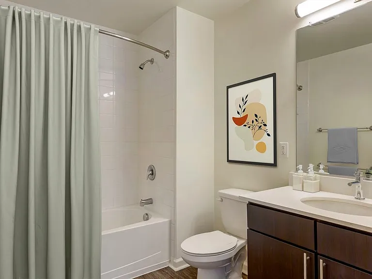 Renovated Package I bath with white quartz countertops, espresso cabinetry, and hard surface flooring