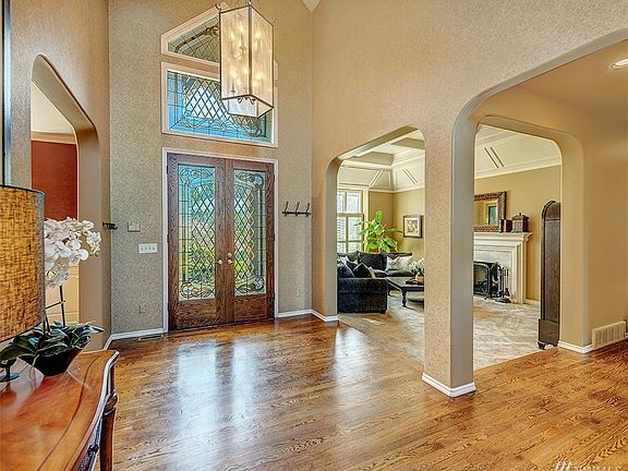 Beautiful Foyer With Custom Chandelier, Leaded Window, And Hardwood Floors.