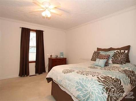 Master bedroom with adjoining ful bath, ceiling fan and crown molding.