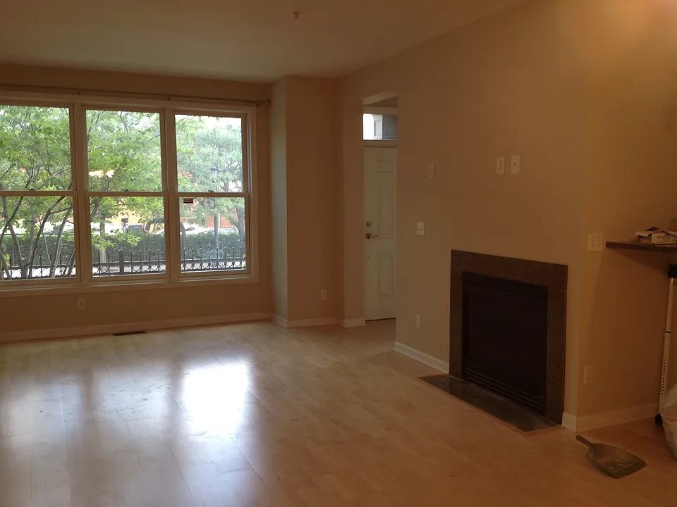 Sunny living room that is open to the dining room with gas f