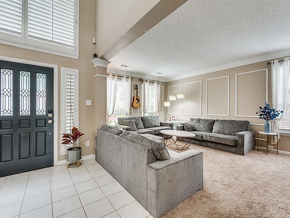 Entryway with white tile flooring and decorative paneling