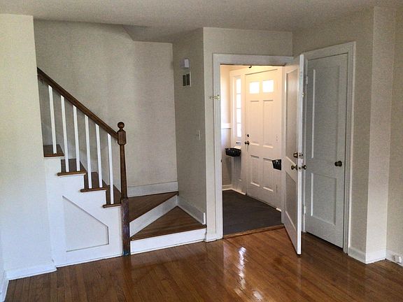 Living room to front entrance and stairway up.