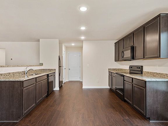 The kitchen features granite countertops and stunning wood cabinetry