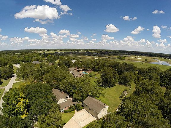 This bird's eye view showcases how the home is sheltered in amongst the trees.  It also provides a look at the 3-car detached Garage with the Quarters above.  The property stretches past the back fence all the way to Holmes Road