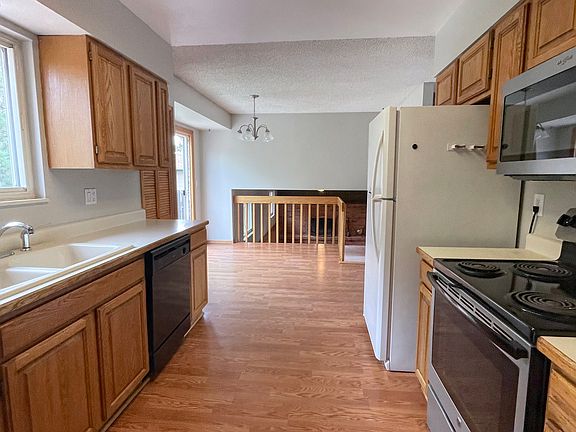 Galley kitchen leading to dining area. Easy care luxury vinyl floors. Oak cabinets and good natural light