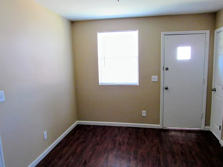Breakfast nook opposite the kitchen, with another storage closet and the side door that leads to the fenced in backyard.