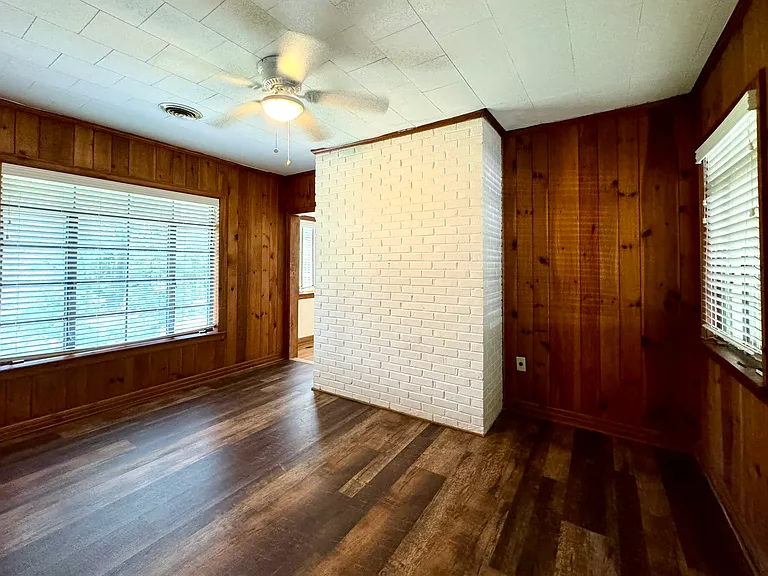 Den with original wood plank walls, new laminate flooring.