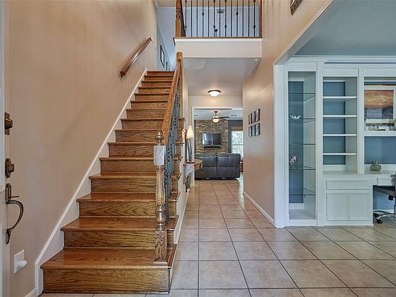 The inviting entry with solid oak staircase with wrought iron railings greets you as you enter the home!