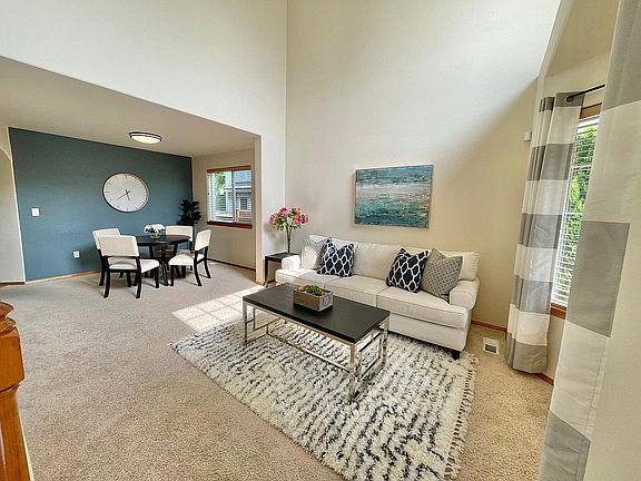 Open concept formal living room + dining room, with vaulted ceilings.