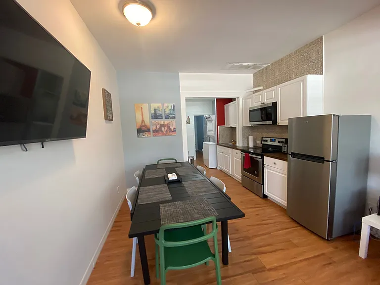 Bright dining room with 6 chairs and their respective placemats and TV