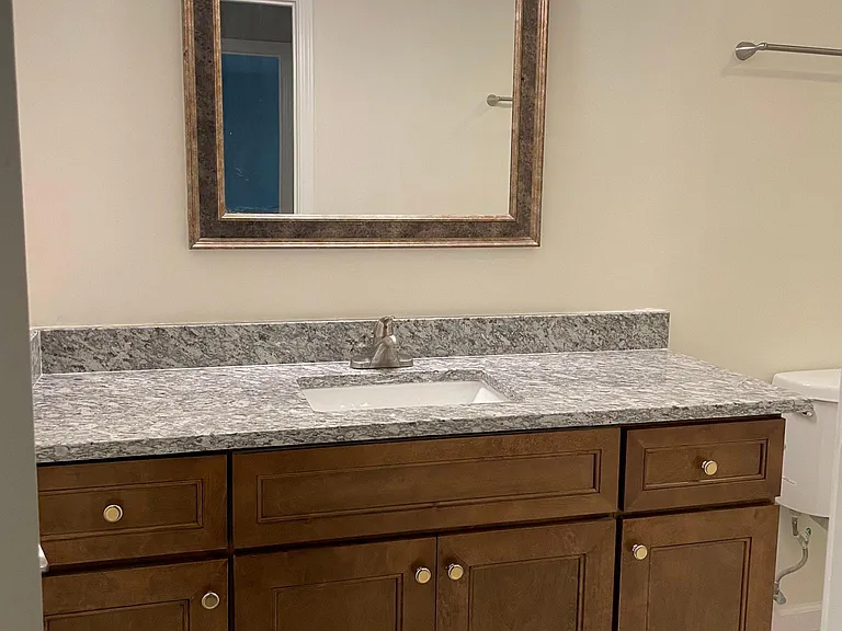 Bathroom with ceramic tile floor and vanity with granite top & LED lighting.