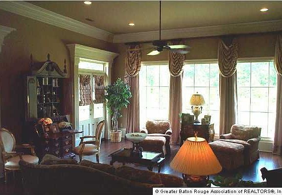 Living room with fireplace, high ceilings, special millwork, and antique heart