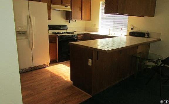 Kitchen with upgraded laminate flooring and tile counters