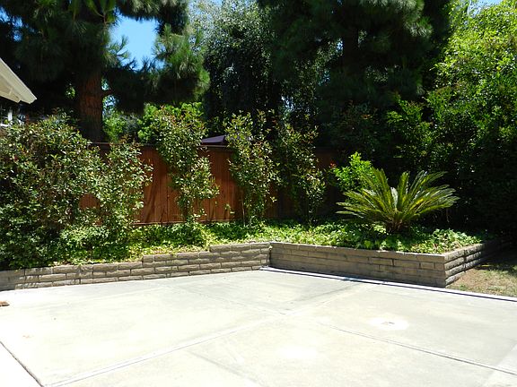 Partial backyard view from side yard on kitchen side of the home.