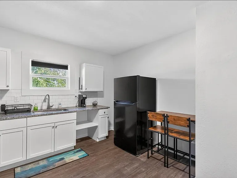 Efficient kitchen with ample cabinet storage, generous counter space, and a full-size refrigerator plus a handy eat-in nook.