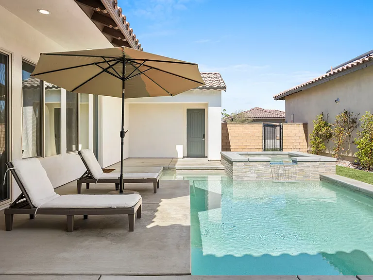Double outdoor loungers are available for your convenience under the large umbrella.