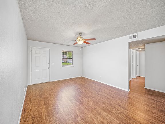 Living room looking towards front door. Hallway in picture leads to bedrooms and bathrooms.